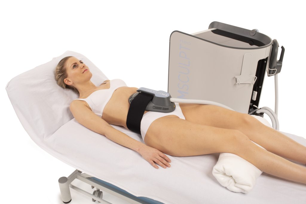 Model demonstrating what Emsculpt Neo machine looks like when attached to abdomen